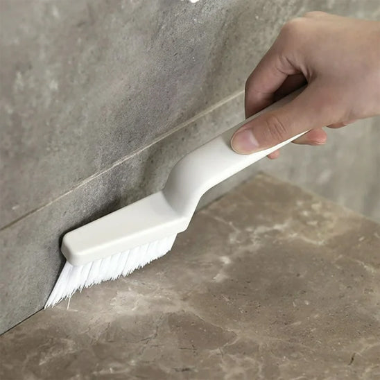 Brosse a joint JointPro utilisée dans un coin mural des toilettes